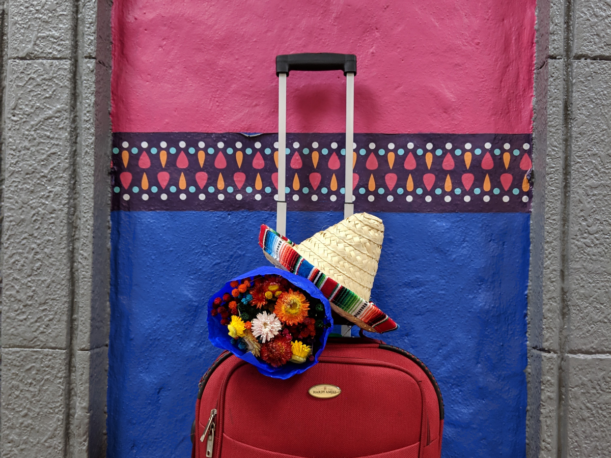 Maleta roja con ramo de flores y sombrero — listos para partir juntos